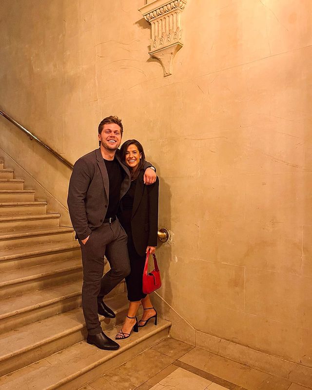 Nico Hoerner and Julia Ditosto posing on the stairs of a building